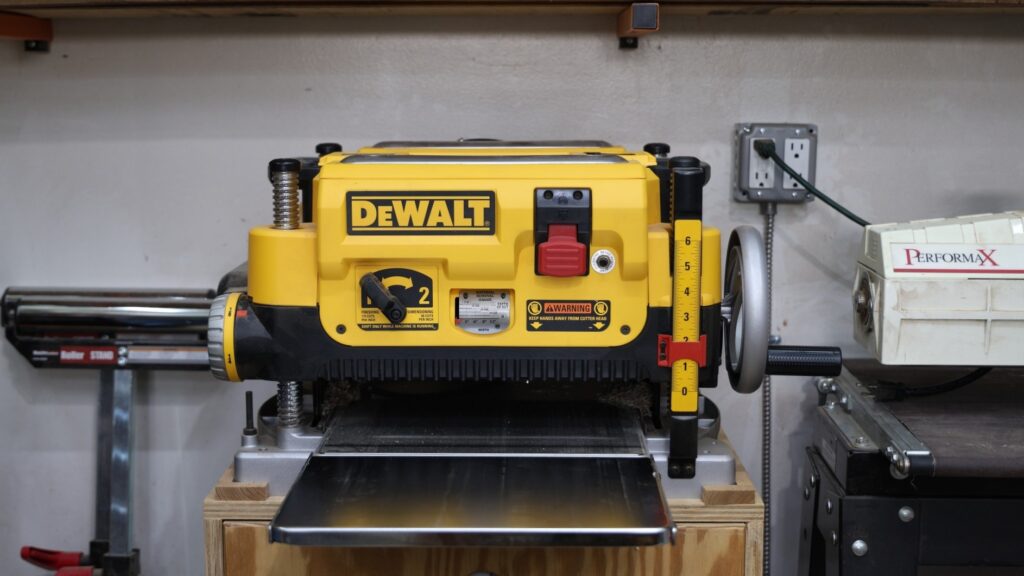 DeWalt 735x planer mounted on a wooden stand in a woodworking shop