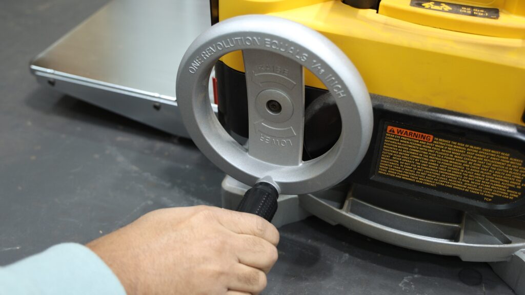 Close-up of crank handle on DeWalt 735x planer used for height adjustment