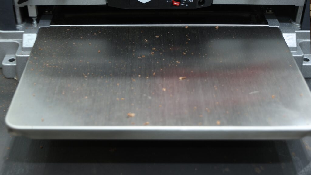 Planer bed surface with wood chips after dust collection test using a 4-inch hose