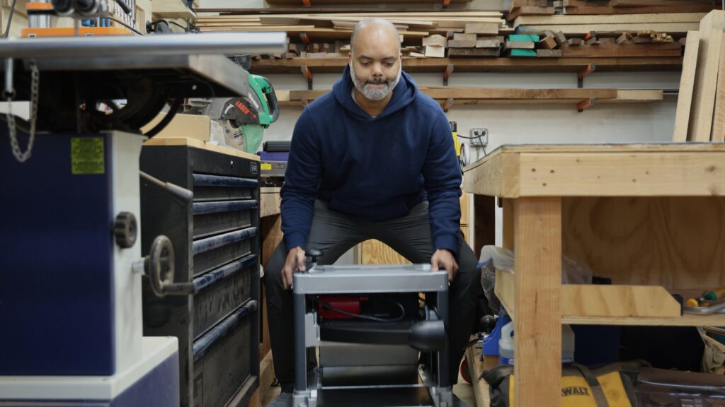 Man lifting the FindBuyTool FB131H planer off the ground in a workshop