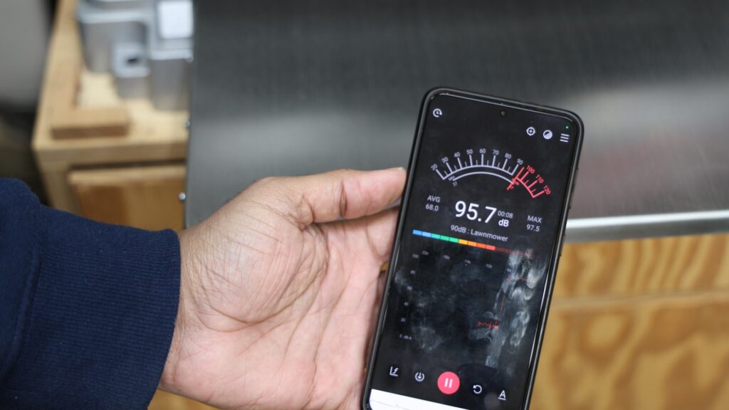 Smartphone decibel meter reading 95.7 dB next to the FindBuyTool FB131H planer during operation