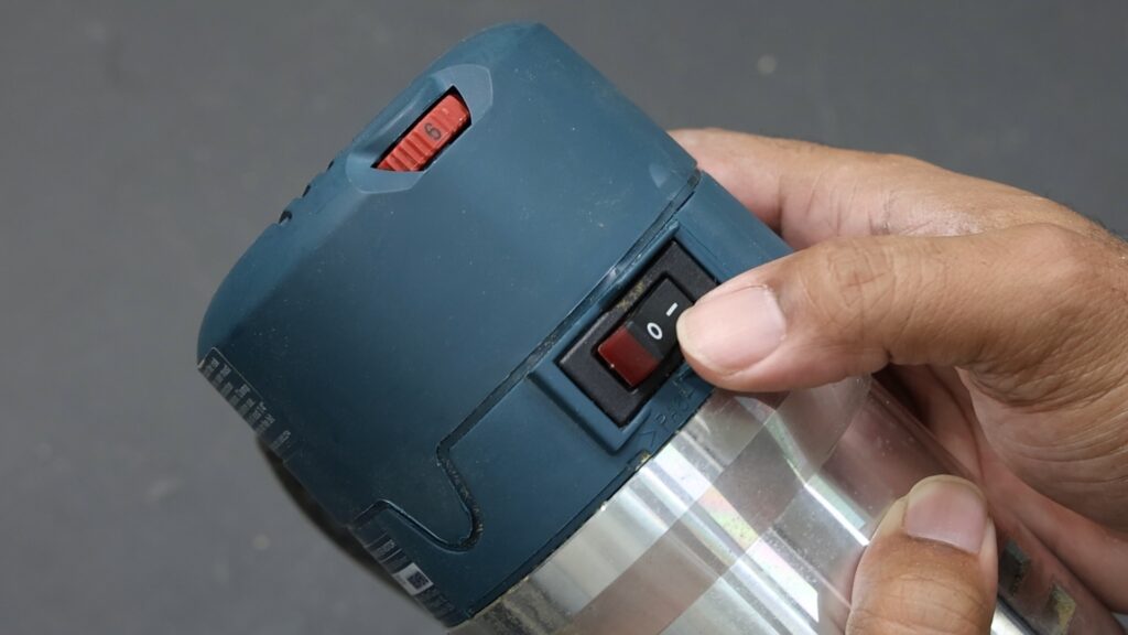 Close-up of Bosch 1617EVSPK router’s power switch and variable speed dial.