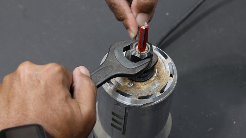 Using two wrenches to loosen the collet on the Bosch router motor.