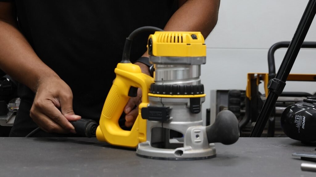 Installing the removable power cord into DeWalt DW618PKB D-handle router base.