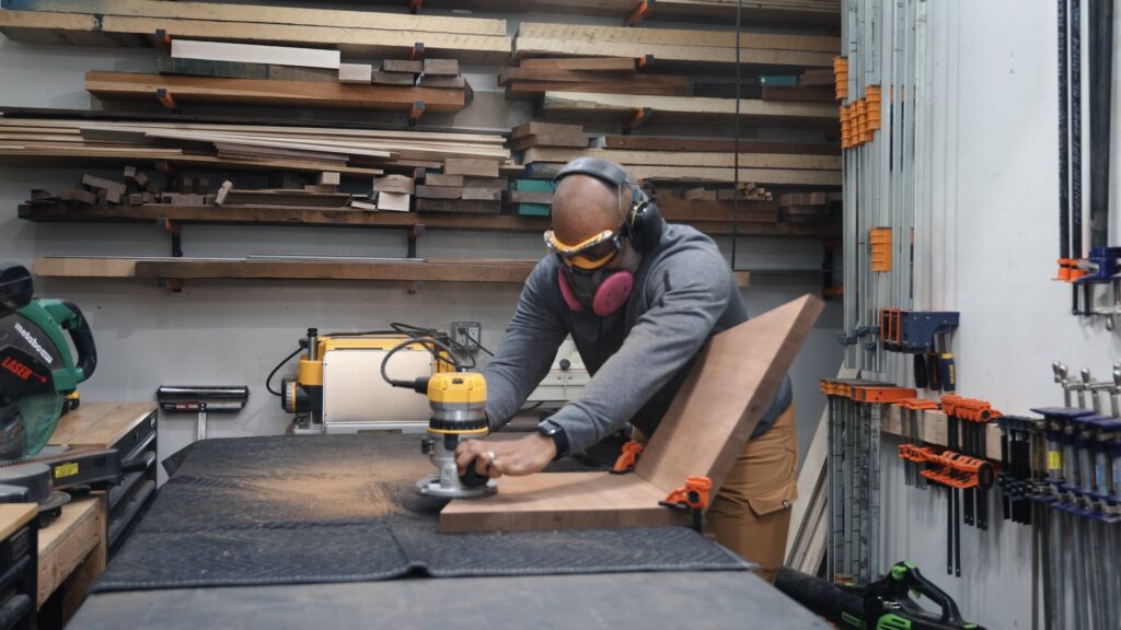 Woodworker using sander with DeWalt safety goggles and hearing protection