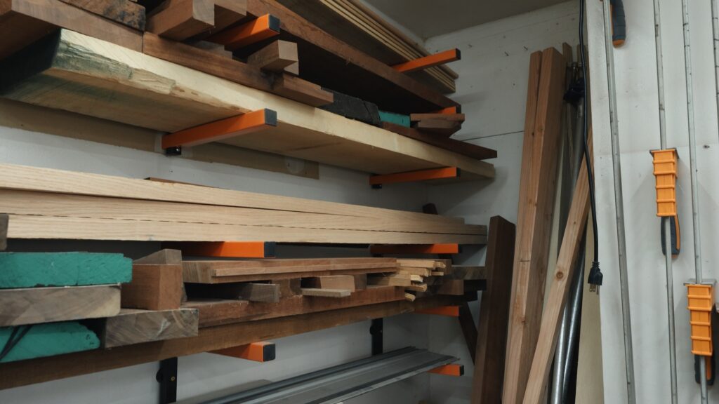 Kastforce wall mounted lumber storage racks holding hardwood boards