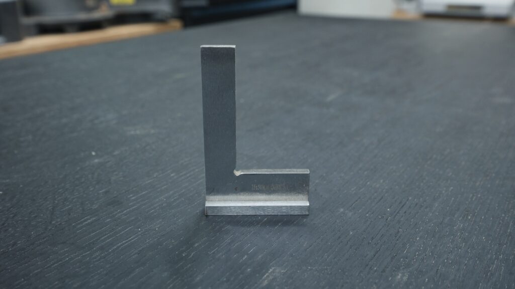 Three inch hardened steel machinist square standing upright on work surface