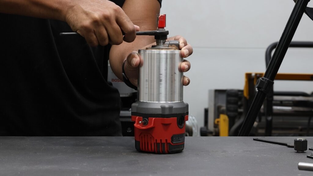 Using the spindle lock button on the SKIL router while tightening the collet with a wrench.