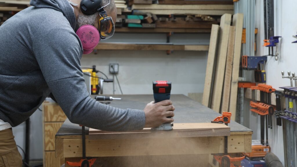 Bosch GKF18V-25 cordless trim router cutting a rabbet in hardwood