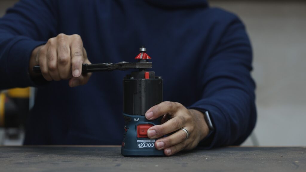 Red spindle lock switch on the Bosch GKF18V-25 enabling one-handed bit changes