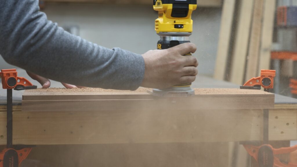 DeWalt DCW600B cordless trim router cutting a rabbet in hardwood